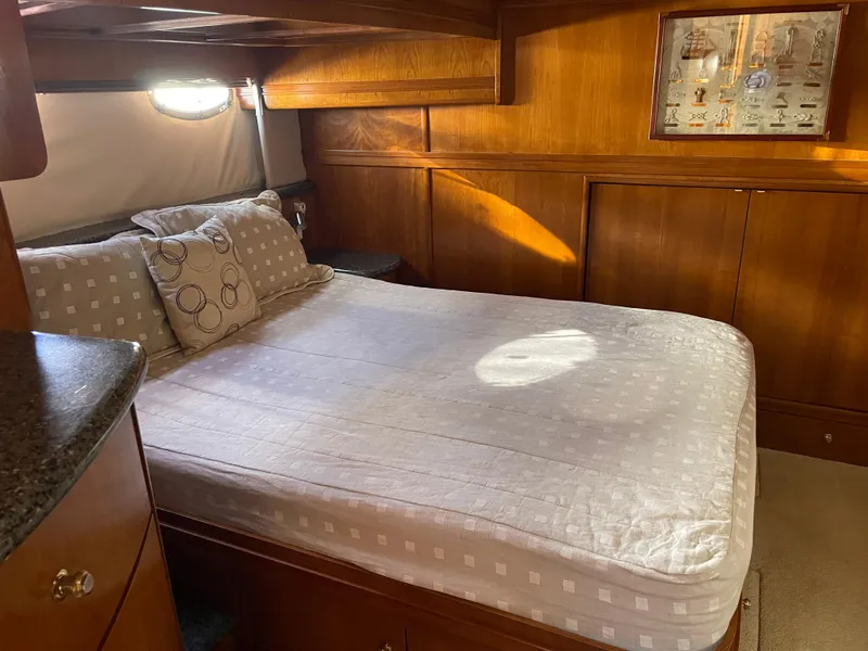 Slide: The Image of Luxurious bedroom in 2000 Carver 530 Voyager Pilothouse yacht with wood paneling and cozy bedding. - 21