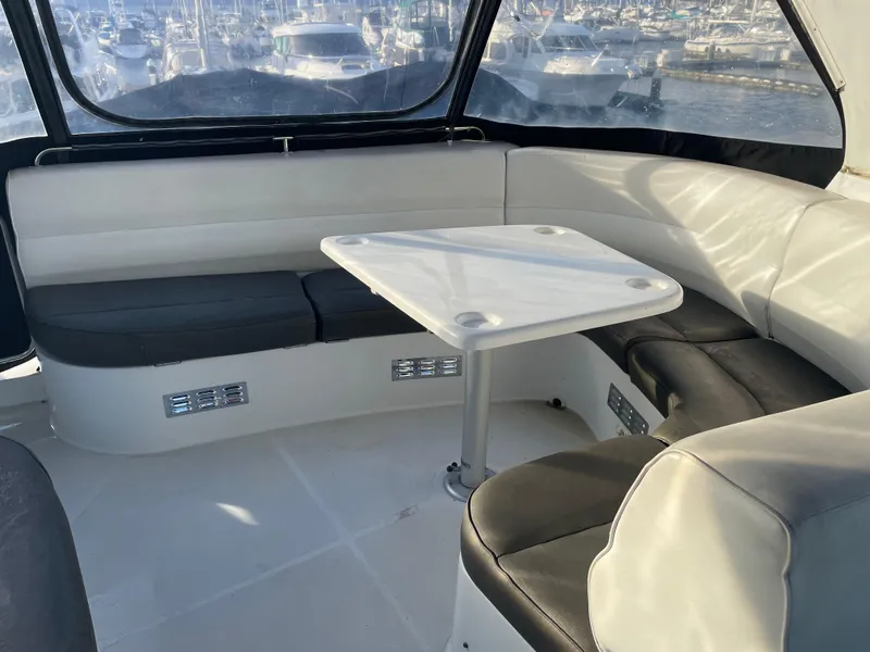 Slide: The Image of 2000 Carver 530 Voyager Pilothouse interior with seating and table, overlooking marina. - 47