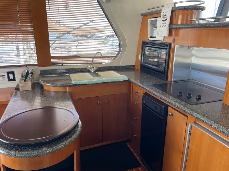 Slide: The Image of Interior kitchen of 2000 Carver 530 Voyager Pilothouse with modern appliances and wood cabinetry. - 7