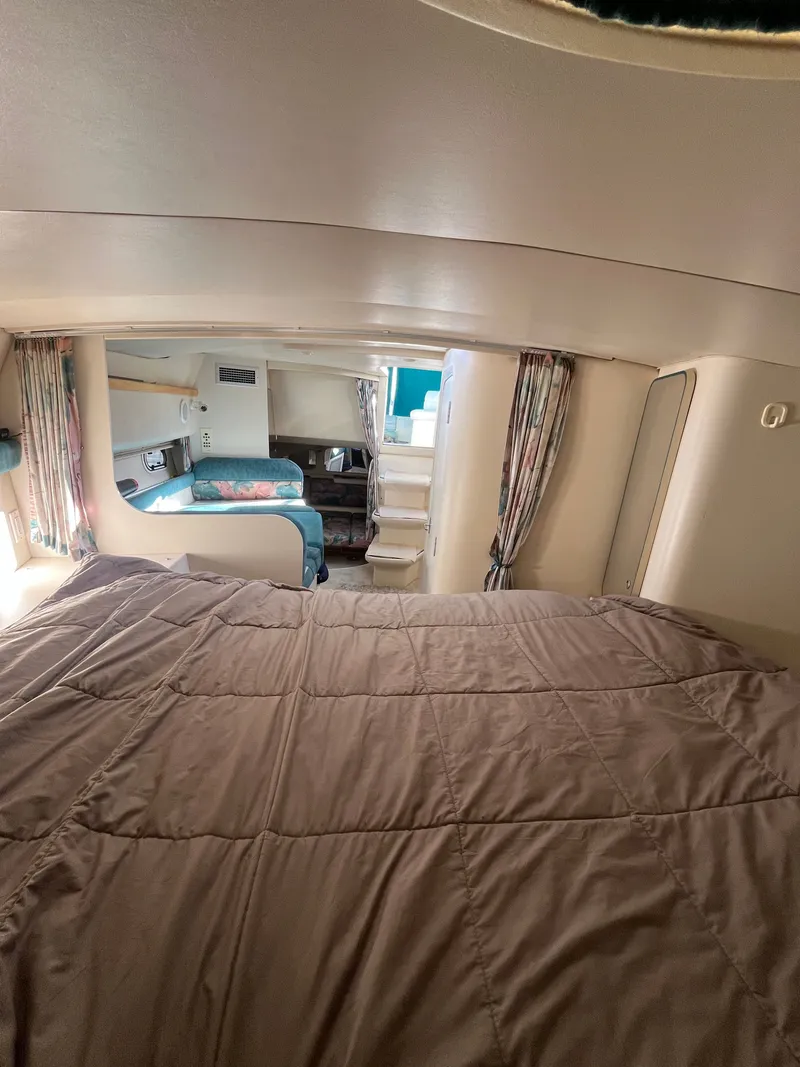 Slide: The Image of Interior cabin of a 1996 Cruisers Yachts 3375, featuring a cozy bed and seating area. - 11