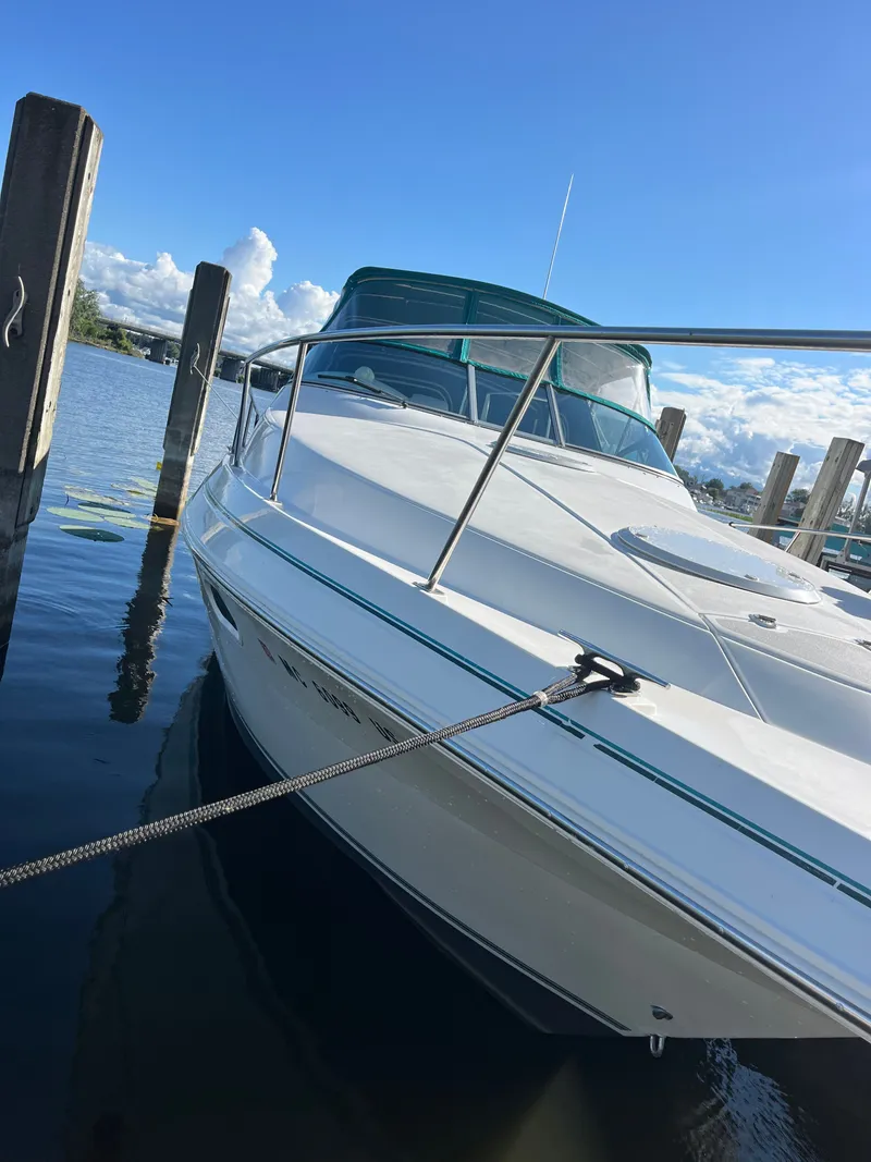 Slide: The Image of 1996 Cruisers Yachts 3375 docked on a sunny day, showcasing sleek design and water reflections. - 2