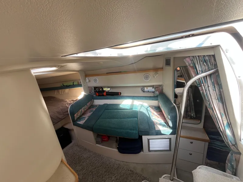 Slide: The Image of Interior of 1996 Cruisers Yachts 3375, featuring cozy seating and sleeping area. - 7