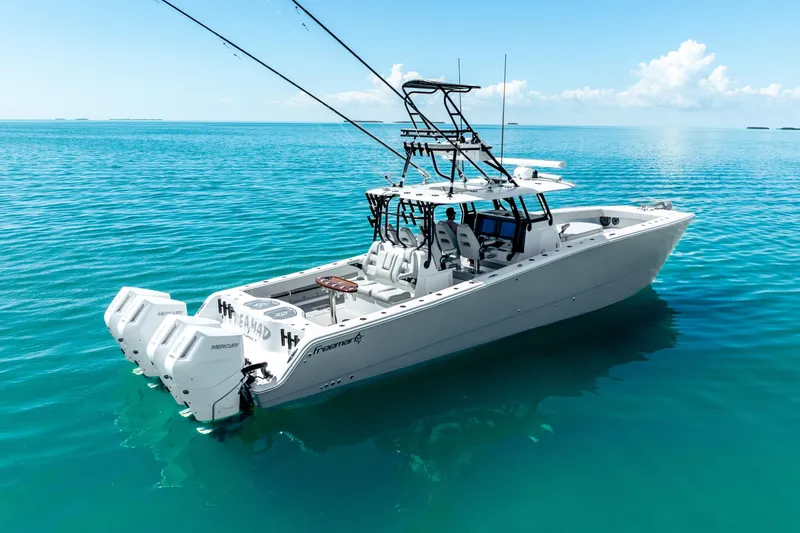 Slide: The Image of 2024 Freeman 42 boat on clear blue water, featuring powerful Mercury engines. - 2