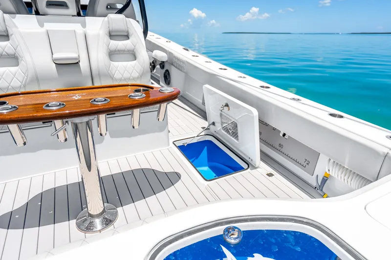 Slide: The Image of 2024 Freeman 42 boat interior with luxury seating and fishing rod holders on a sunny day. - 40