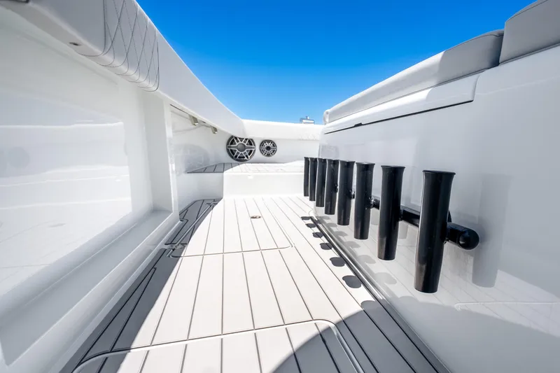 Slide: The Image of 2024 Freeman 42 boat deck with rod holders and sleek design under clear blue sky. - 46
