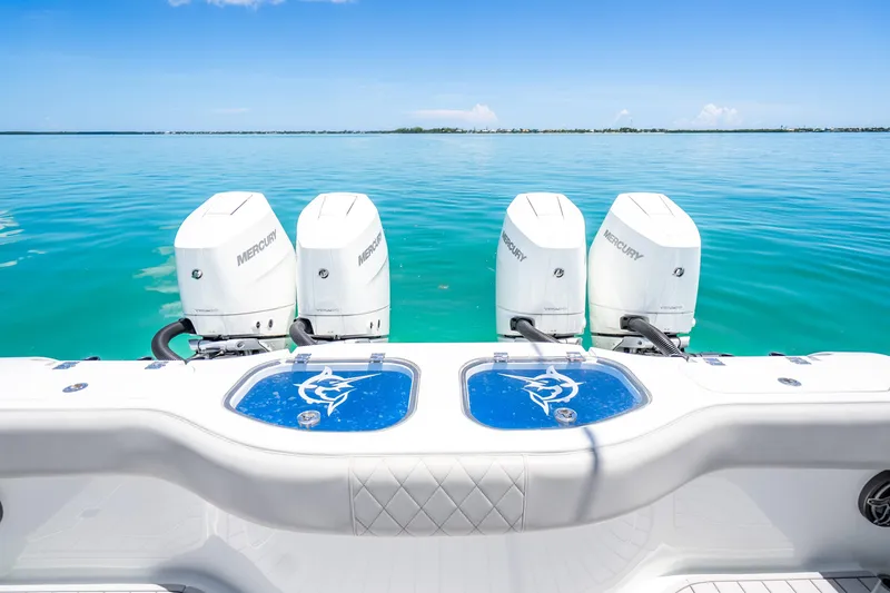 Slide: The Image of 2024 Freeman 42 boat with four Mercury engines on clear blue water. - 48