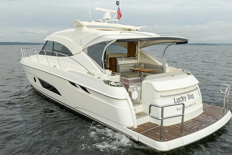 Slide: The Image of 2018 Riviera 4800 Sport Yacht cruising on open water, rear view. - 11