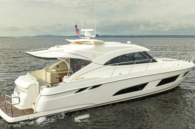 Slide: The Image of 2018 Riviera 4800 Sport Yacht cruising on open water, showcasing sleek design and luxury features. - 13