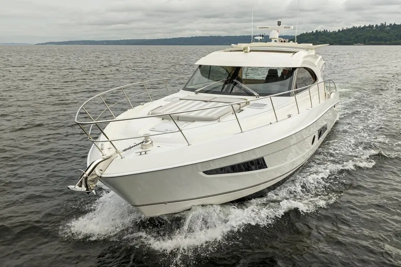 Slide: The Image of 2018 Riviera 4800 Sport Yacht cruising on open water, showcasing sleek design and luxury. - 2