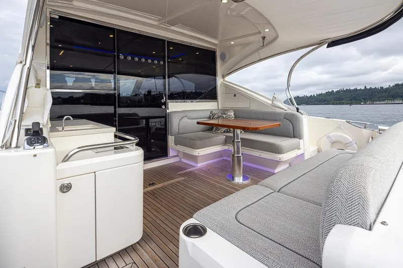 Slide: The Image of 2018 Riviera 4800 Sport Yacht interior with elegant seating and scenic water view. - 22
