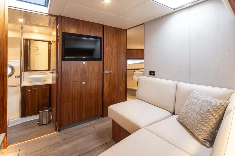 Slide: The Image of Interior of 2018 Riviera 4800 Sport Yacht with modern furnishings and wood accents. - 28
