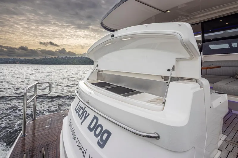 Slide: The Image of 2018 Riviera 4800 Sport Yacht on water, open storage, sunset view. - 47