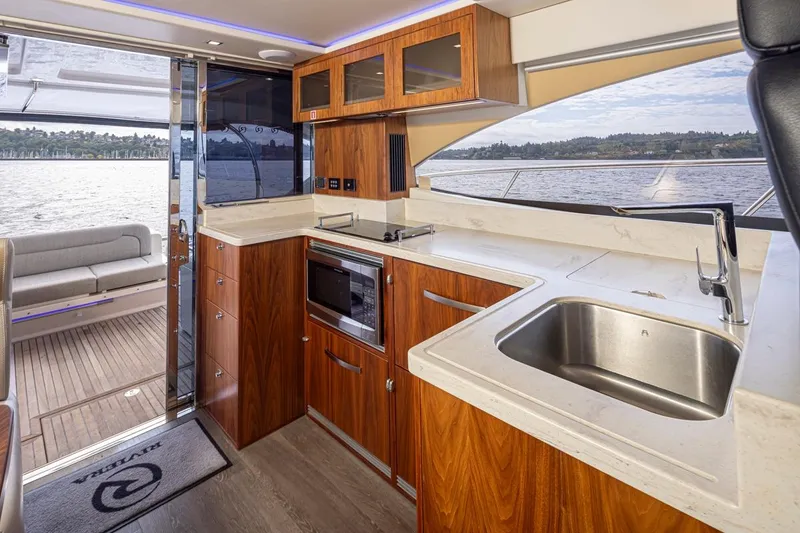 Slide: The Image of Luxurious interior of 2018 Riviera 4800 Sport Yacht with modern kitchen and scenic water view. - 49