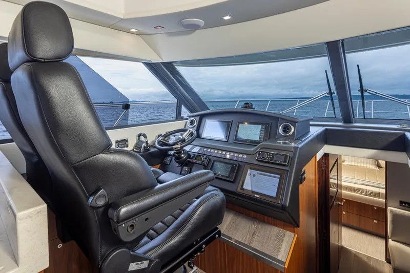 Slide: The Image of 2018 Riviera 4800 Sport Yacht helm with leather captain's chair and advanced navigation systems. - 50