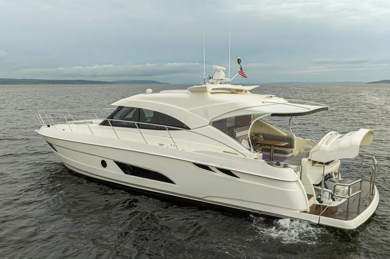Slide: The Image of 2018 Riviera 4800 Sport Yacht cruising on open water under cloudy skies. - 9