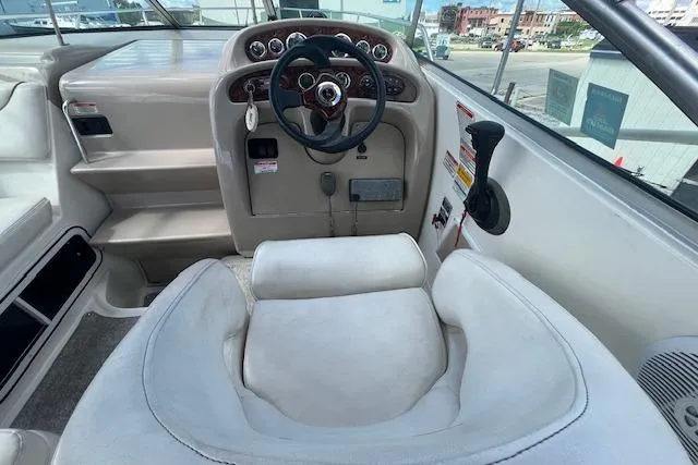 Slide: The Image of 2003 Sea Ray 260 Sundancer helm with steering wheel and control panel. - 13