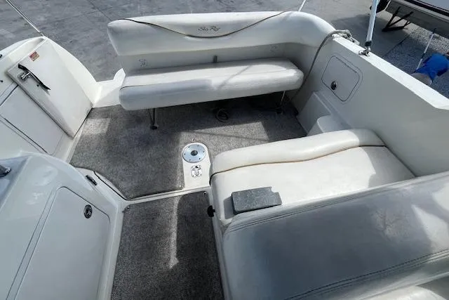 Slide: The Image of 2003 Sea Ray 260 Sundancer boat interior with white seating and carpeted floor. - 20