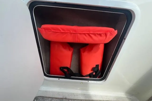 Slide: The Image of Red life jackets stored in a compartment on a 2003 Sea Ray 260 Sundancer boat. - 21
