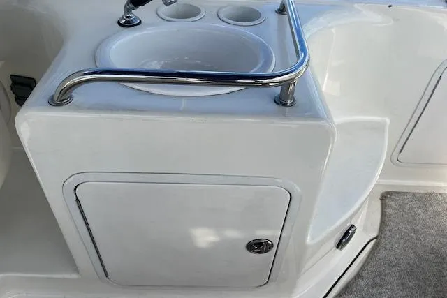 Slide: The Image of 2003 Sea Ray 260 Sundancer boat sink and storage area with stainless steel rail. - 22