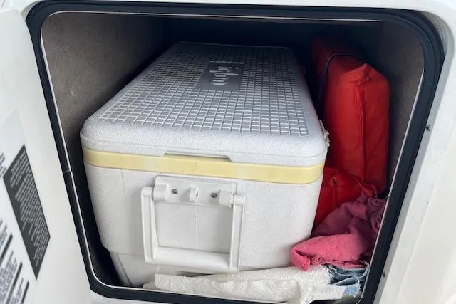 Slide: The Image of Storage compartment in a 2003 Sea Ray 260 Sundancer with cooler and life jacket. - 23