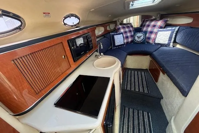 Slide: The Image of 2003 Sea Ray 260 Sundancer cabin interior with kitchenette and cozy seating area. - 25
