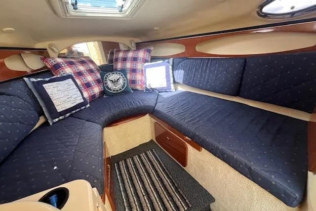 Slide: The Image of 2003 Sea Ray 260 Sundancer cabin with blue seating, plaid pillows, and striped rug. - 30