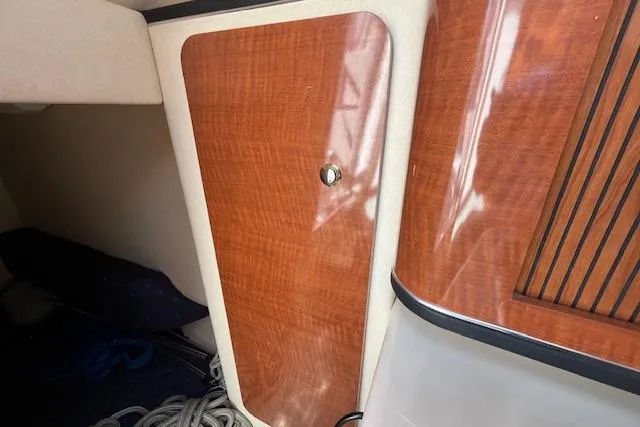 Slide: The Image of 2003 Sea Ray 260 Sundancer cabin interior with wood finish and storage compartment. - 38