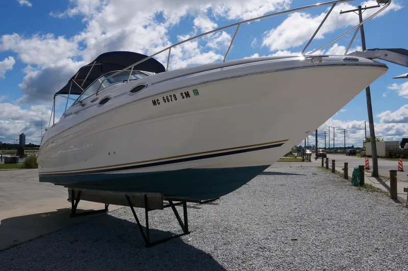 Slide: The Image of 2003 Sea Ray 260 Sundancer boat on dry dock under a clear blue sky. - 4