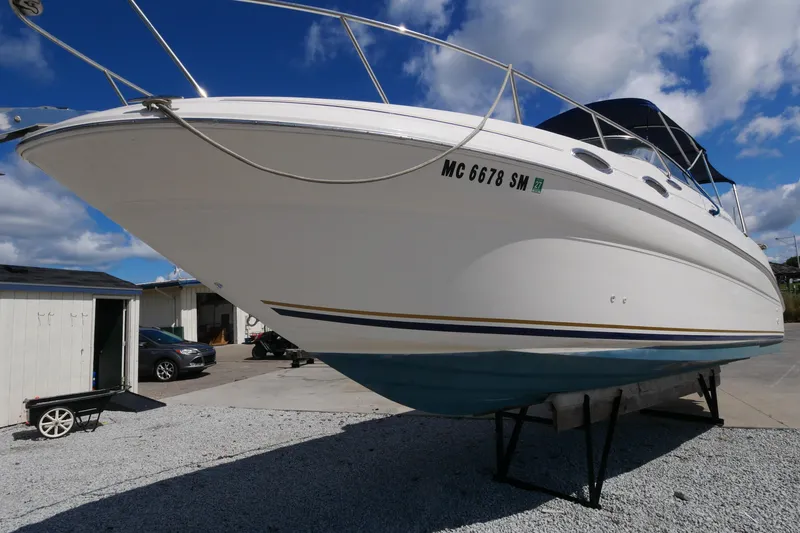 Slide: The Image of 2003 Sea Ray 260 Sundancer boat on dry dock under blue sky. - 5