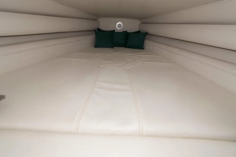 Slide: The Image of Interior cabin of 1999 Fountain 38 Lightning boat with white bedding and green pillows. - 10