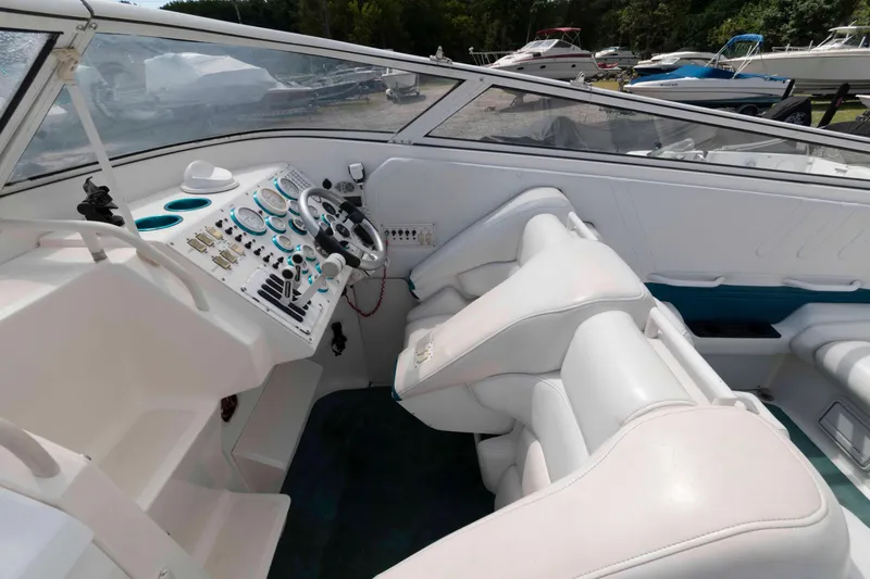 Slide: The Image of 1999 Fountain 38 Lightning boat cockpit with white leather seats and control panel. - 5