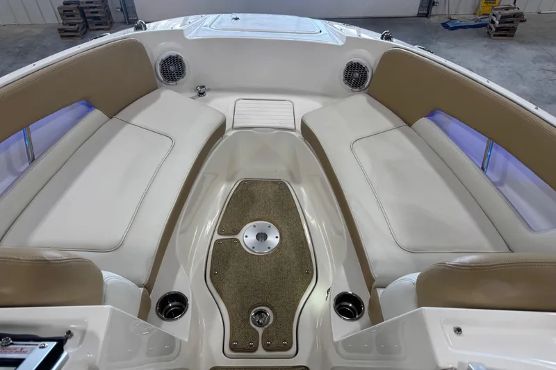 Slide: The Image of 2011 Sea Ray 240 Sundeck interior with beige seating and carpeted floor. - 12