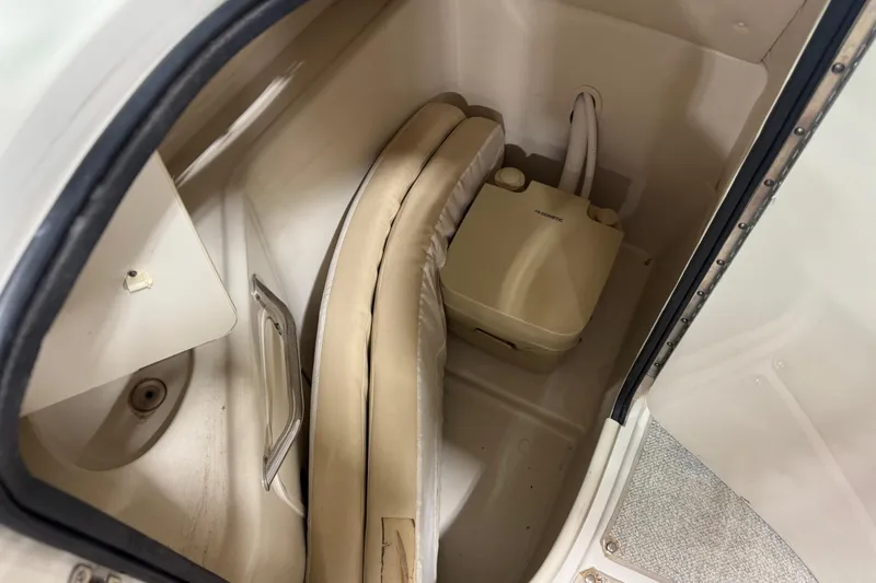 Slide: The Image of 2001 Sea Ray 240 Sundeck interior storage with portable toilet and cushions. - 12