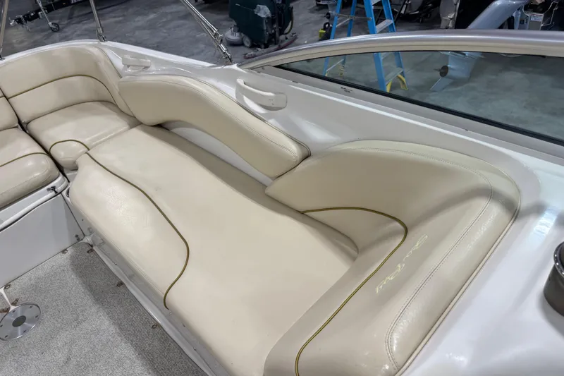 Slide: The Image of 2001 Sea Ray 240 Sundeck interior with beige leather seating and sleek design. - 13