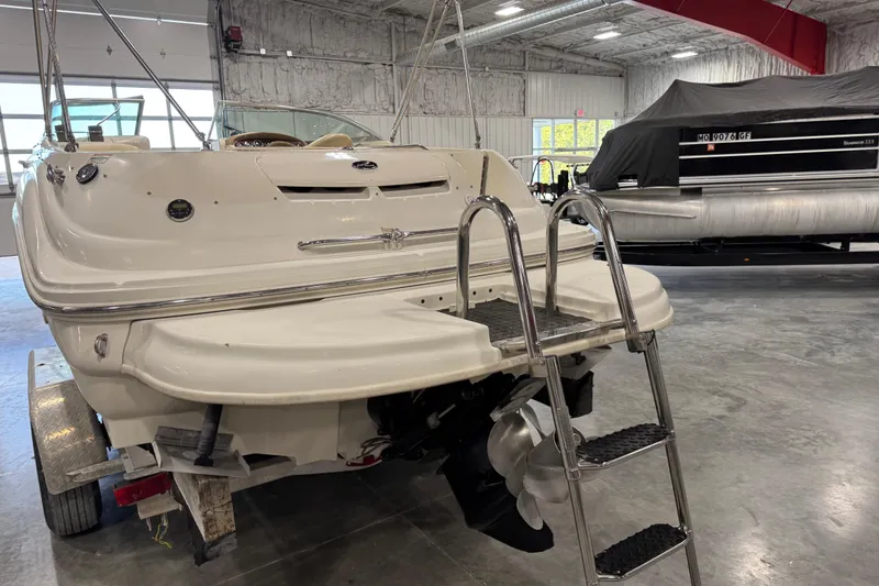 Slide: The Image of 2001 Sea Ray 240 Sundeck boat in indoor storage, rear view with ladder. - 6