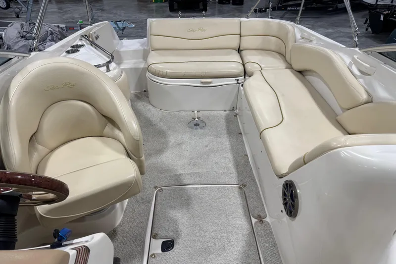 Slide: The Image of Interior of a 2001 Sea Ray 240 Sundeck boat with beige seating and carpeted floor. - 7