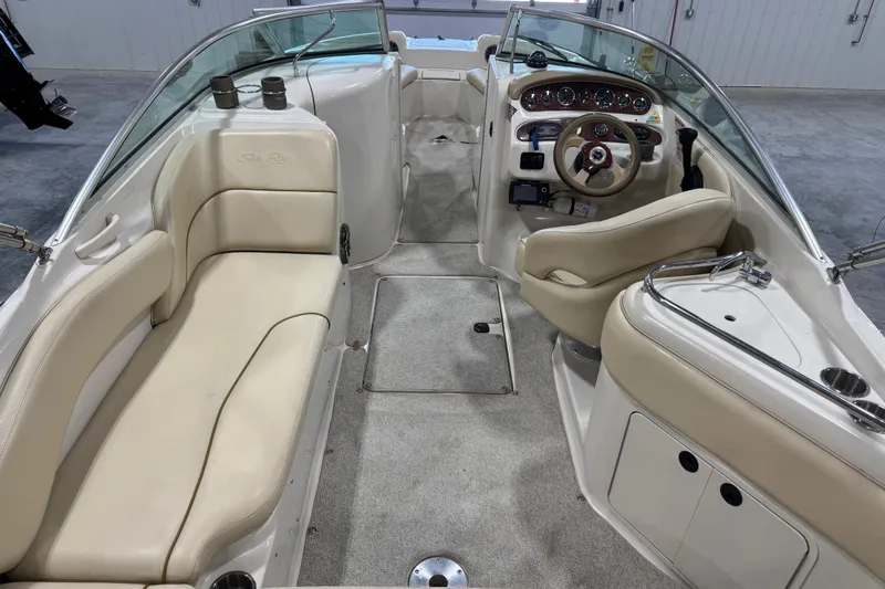 Slide: The Image of 2001 Sea Ray 240 Sundeck interior with beige seating and steering console. - 9