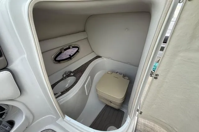 Slide: The Image of 2021 Crownline Eclipse E235 XS boat interior with compact bathroom and sink. - 7