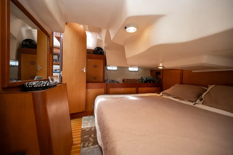 Slide: The Image of Cozy cabin interior of 1999 Hunter 410 sailboat with wooden furnishings and bed. - 18
