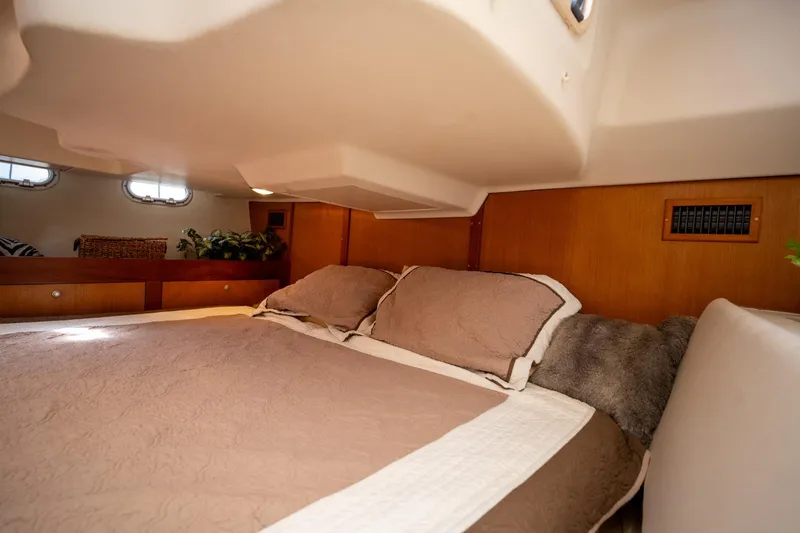 Slide: The Image of Cozy cabin interior of 1999 Hunter 410 sailboat with comfortable bedding and wooden accents. - 19