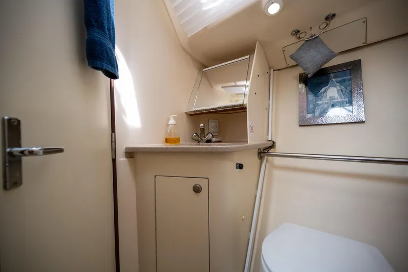 Slide: The Image of 1999 Hunter 410 yacht bathroom with sink, mirror, and towel rack. - 20