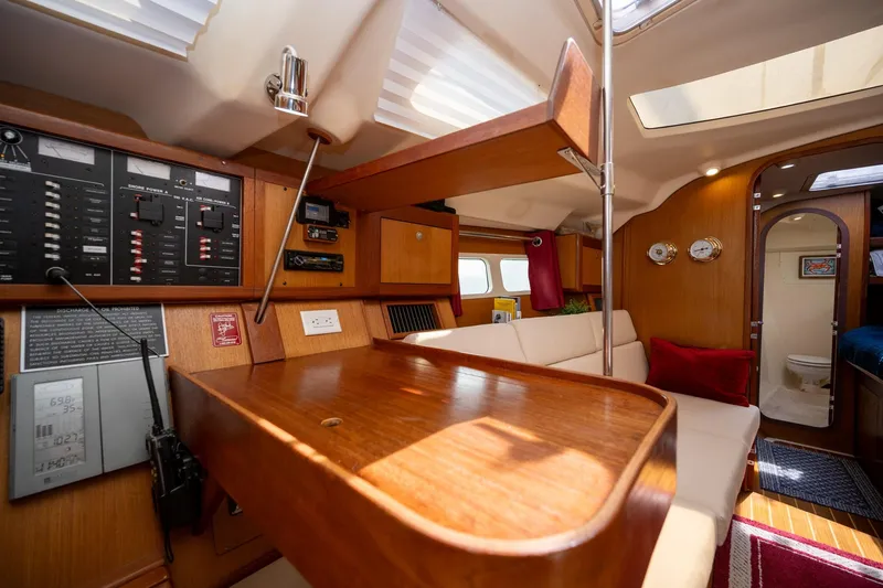Slide: The Image of Interior of a 1999 Hunter 410 sailboat with wood paneling and navigation controls. - 24