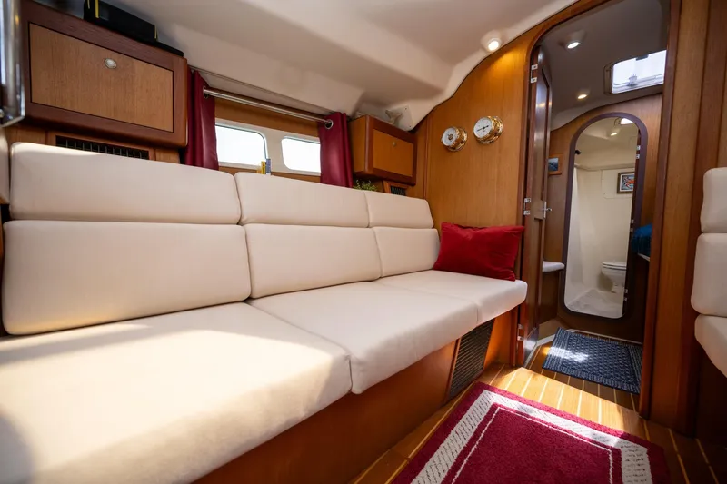 Slide: The Image of Interior of a 1999 Hunter 410 yacht with beige seating and wooden accents. - 25
