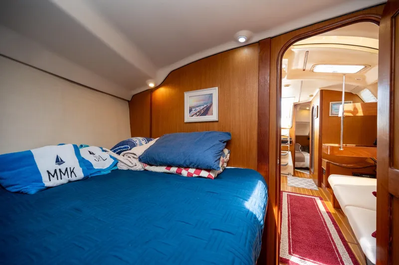 Slide: The Image of Cozy cabin interior of 1999 Hunter 410 sailboat with blue bedding and wooden accents. - 28