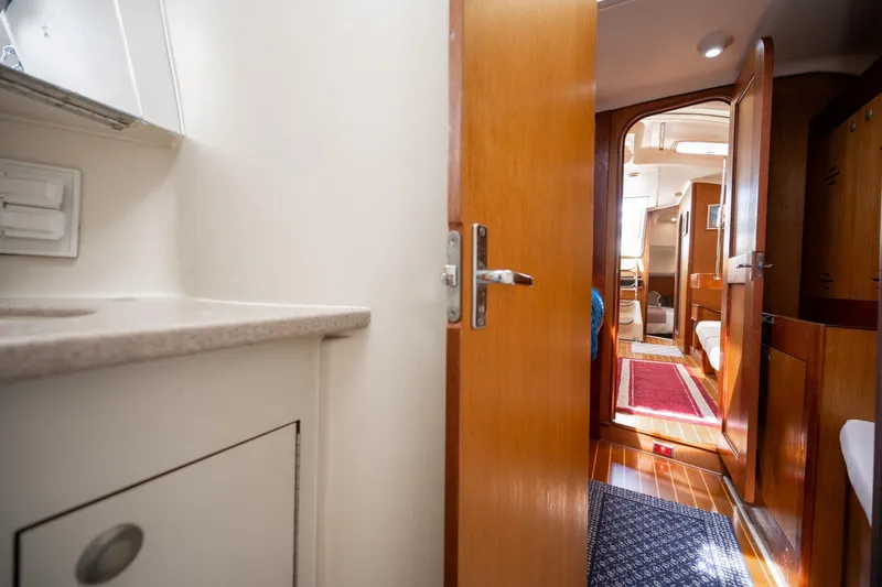 Slide: The Image of Interior view of a 1999 Hunter 410 sailboat, featuring wooden doors and a compact cabin layout. - 31