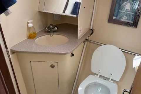 Slide: The Image of 1999 Hunter 410 boat bathroom with sink, mirror, and toilet. - 9