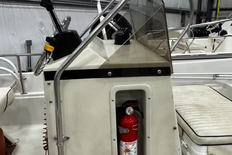 Slide: The Image of 1991 Boston Whaler 17 Montauk boat console with steering wheel and fire extinguisher. - 10