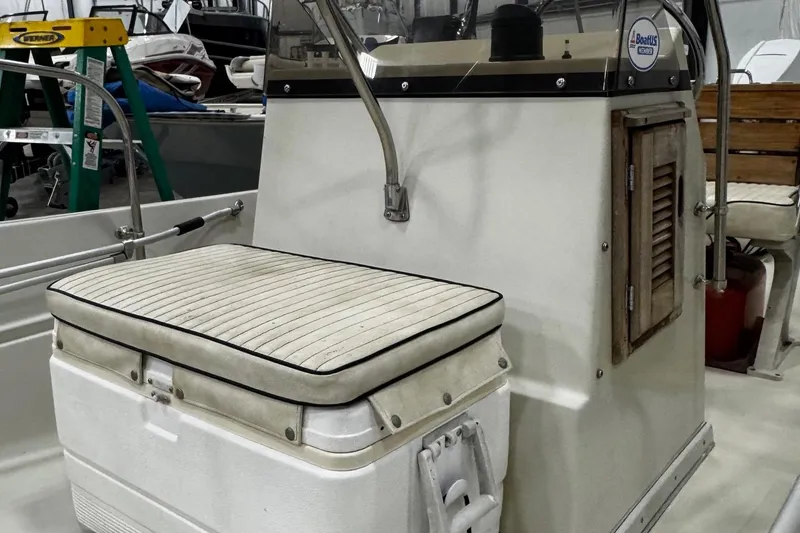 Slide: The Image of 1991 Boston Whaler 17 Montauk boat interior with cushioned seating and console. - 11