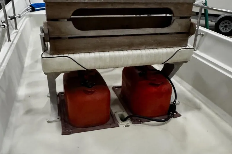 Slide: The Image of 1991 Boston Whaler 17 Montauk interior with red fuel tanks and wooden seat. - 14