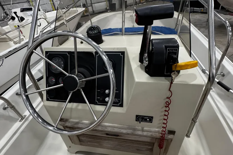 Slide: The Image of 1991 Boston Whaler 17 Montauk boat console with steering wheel and controls. - 18